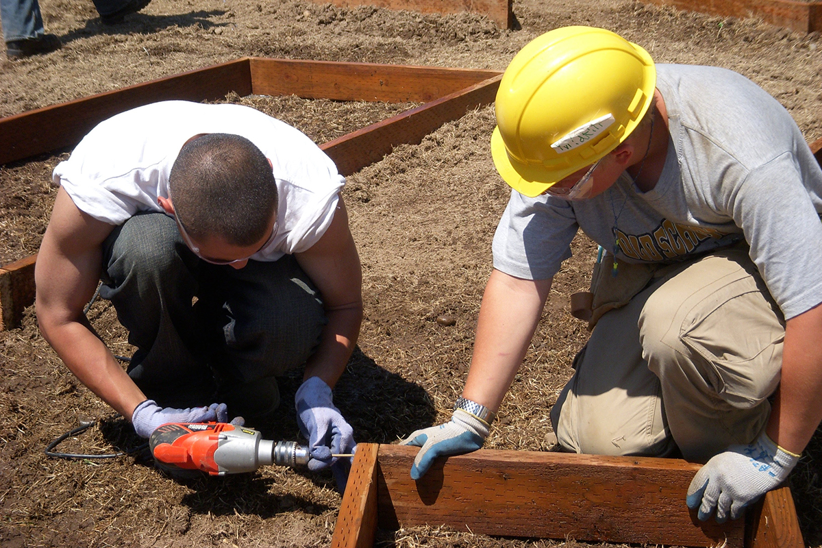 Instructor and student using drill to build garden box
