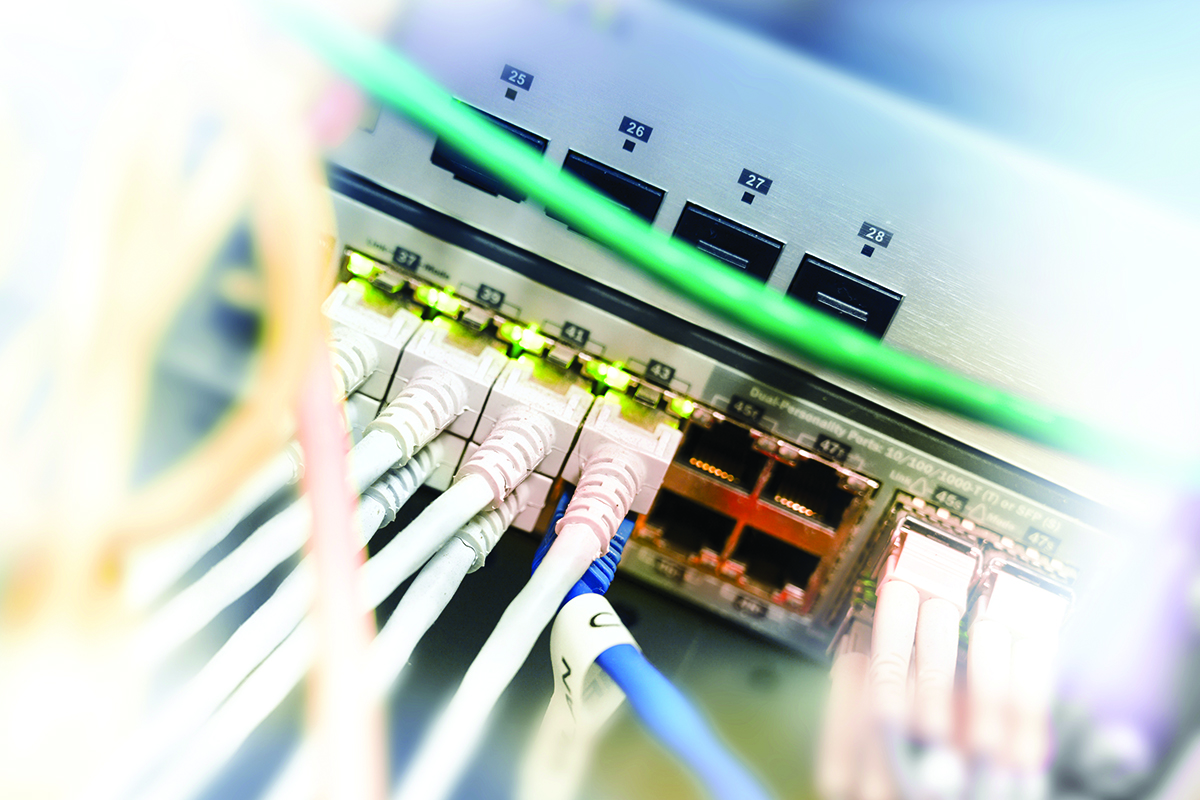 Network server rack with ethernet cables on switches in a data system center, selected focus, narrow depth of field