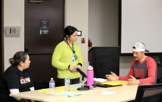 Mirla Cobb talking with a Head Start to Success parent and the leader of their policy council at a council meeting