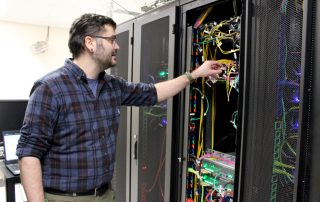 John Gates adjusting wires in the server room