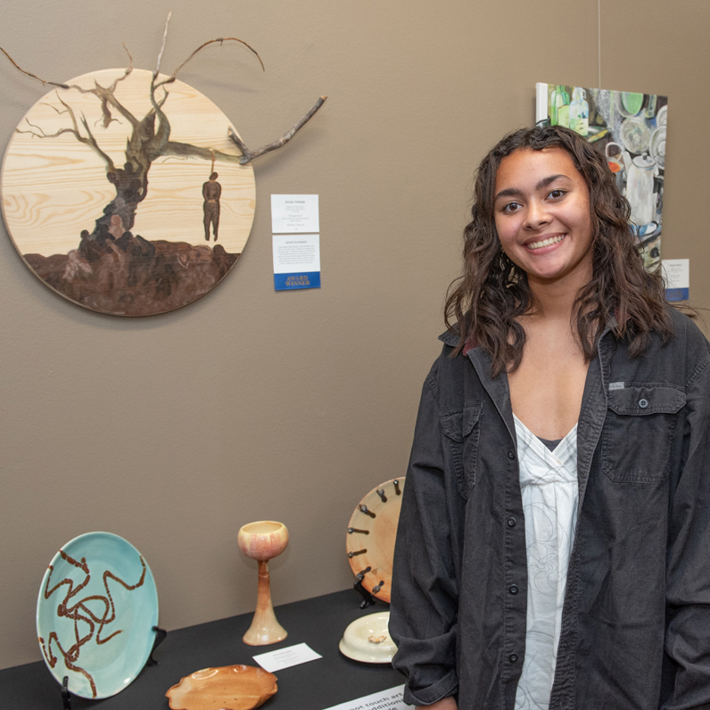 Student posing with her artwork at the 2024 Clackamas ESD Regional Art Show